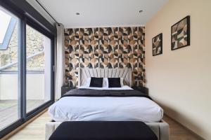 a bedroom with a large bed and a large window at MM Suites Town House Terrasse in Reims