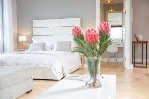 a vase of pink flowers on a table in a bedroom at 17 Feverberry in Ballito