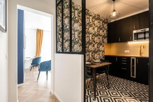 a kitchen with a table and a dining room at MM Suites Marlot in Reims