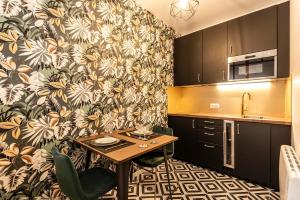 a kitchen with a small table in a kitchen at MM Suites Marlot in Reims
