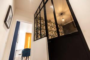 a hallway with a black door and a chair at MM Suites Marlot in Reims
