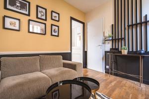 a living room with a couch and a table at MM Suites Reims Centre Terasse in Reims