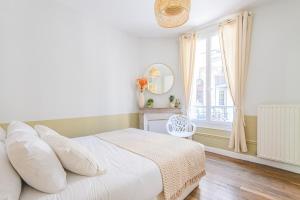 a white bedroom with a bed and a window at MM Suites Reims Centre Terasse in Reims