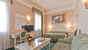 Habitación de hotel con cama y sala de estar. en Hotel Terme Roma en Abano Terme