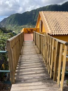 a wooden boardwalk leading to a house with a table at Yellow Attic in Senhora do Rosário