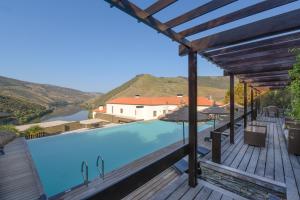 a swimming pool with a view of a river and mountains at Hotel Rural Quinta Do Pego in Tabuaço