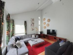 a living room with a couch and a tv at Semi-detached house with sauna & yard near city center in Hyvinkää