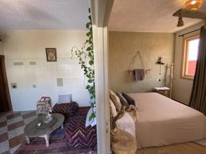 a bedroom with a large bed and a table at The FlowHost in Tamraght Ouzdar