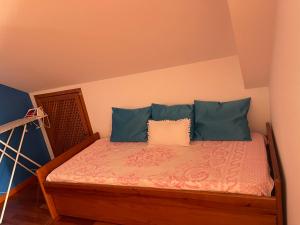 a bedroom with a bed with blue pillows at Yellow Attic in Senhora do Rosário