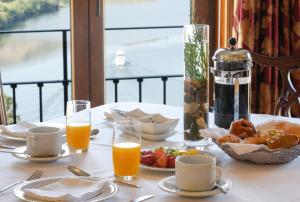a table with a breakfast of orange juice and food at Hotel Rural Quinta Do Pego in Tabuaço