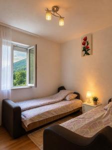 a bedroom with two beds and a window at Lola Guest House in Vusanje