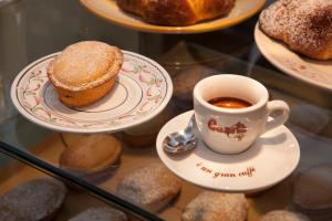 a cup of coffee and pastries in a display case at B&B Express in Leverano