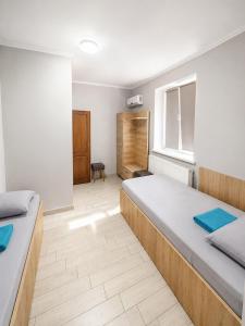 a bedroom with two beds and a window at Hotel Dulgher in Giurgiuleşti