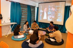 a group of people sitting in a room watching a presentation at Loopin Mcleodganj in McLeod Ganj