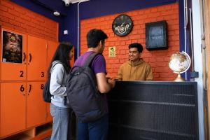 three people standing around a counter in a room at Loopin Mcleodganj in McLeod Ganj