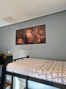 a bed in a room with three pictures on the wall at Refúgio Alemar in Ribeirão Preto +29 photos