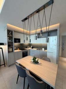 a kitchen with a wooden table and blue chairs at Fontana infinity in Manama