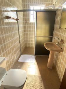 a bathroom with a shower with a toilet and a sink at RCM Vilas - Casa Confortável 02 in Joinville +20 photos