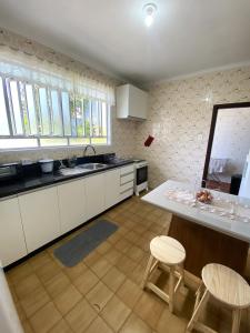 a kitchen with white cabinets and a table and chairs at RCM Vilas - Casa Confortável 02 in Joinville
