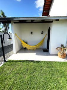 a yellow hammock on the side of a house at RCM Vilas - Casa Confortável 02 in Joinville