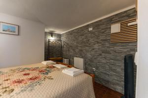 a bedroom with a bed and a brick wall at Casita dos Avós in Alandroal +18 photos