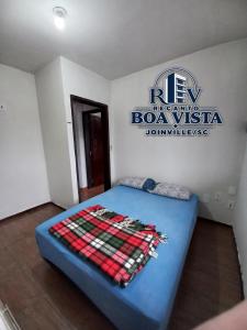 a bed in a room with a sign on the wall at Recanto Boa Vista in Joinville