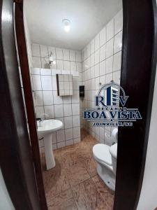 a bathroom with a toilet and a sink at Recanto Boa Vista in Joinville