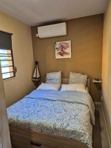 a bedroom with a bed with a blue comforter at Le Ghirol - Tiny Houses & Nature in Quesnel
