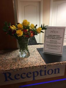 a vase of flowers on a table next to a sign at The Penta in Douglas