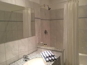a bathroom with a sink and a shower with a shower curtain at The Penta in Douglas