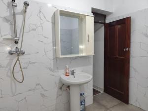 a white bathroom with a sink and a mirror at Barros Homestay in Tarrafal +31 photos