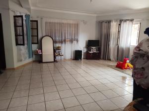 a living room with a large tiled floor and a room with a room at Barros Homestay in Tarrafal