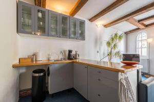a kitchen with white cabinets and a wooden counter top at Anny's Warehouse City Centre! in Amsterdam