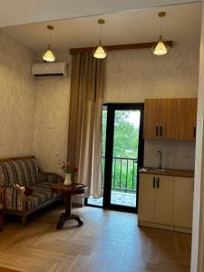 a living room with a couch and a table and a kitchen at ILIAS Guest House in Kvareli