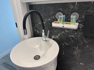 a bathroom with a white sink and two mirrors at Altura House in Almaty +57 photos