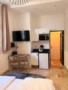 a room with a kitchen and a table with a table at Le Clocher de la Duchesse in Bonnelles