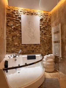 a bathroom with a bath tub and a sink at Le Clocher de la Duchesse in Bonnelles