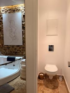 a bathroom with a toilet and a bath tub at Le Clocher de la Duchesse in Bonnelles +43 photos
