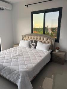 a bedroom with a large bed with a large window at Signature Suite in Bijilo