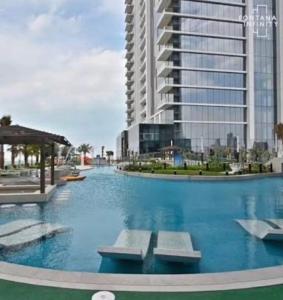 a large swimming pool in front of a tall building at Fontana infinity in Manama +3 photos