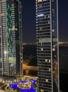a view of two tall buildings at night at Fontana infinity in Manama