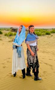 two women standing in the sand on the beach at Hotel Heaven In Jaisalmer in Jaisalmer