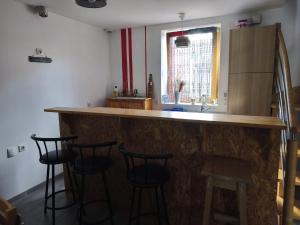 a kitchen with a bar with four bar stools at Maison Relax in Flers +5 photos