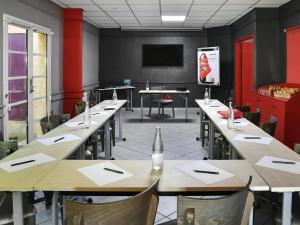 a conference room with tables and chairs and a tv at ibis Sisteron in Sisteron +140 photos