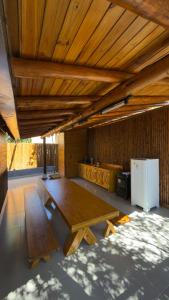 a large room with a wooden table and a refrigerator at Chalé Suíco Vale do Capão in Palmeiras