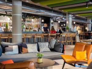 a living room with a couch and a bar at Novotel Annecy Centre in Annecy
