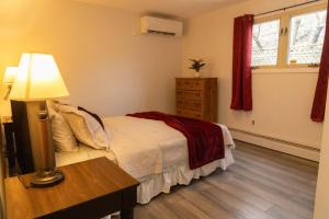 a bedroom with a bed and a table with a lamp at Tranquil Retreats on Robinson in Moncton