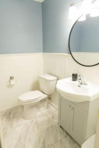 a white bathroom with a toilet and a sink at Tranquil Retreats on Robinson in Moncton