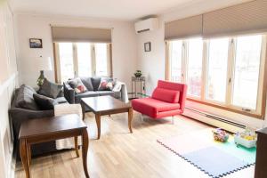 a living room with a couch and a red chair at Tranquil Retreats on Robinson in Moncton +20 photos