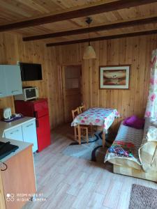 a kitchen and dining room with a table in a cabin at EkoZagroda Goreń Duży in Goreń Duży